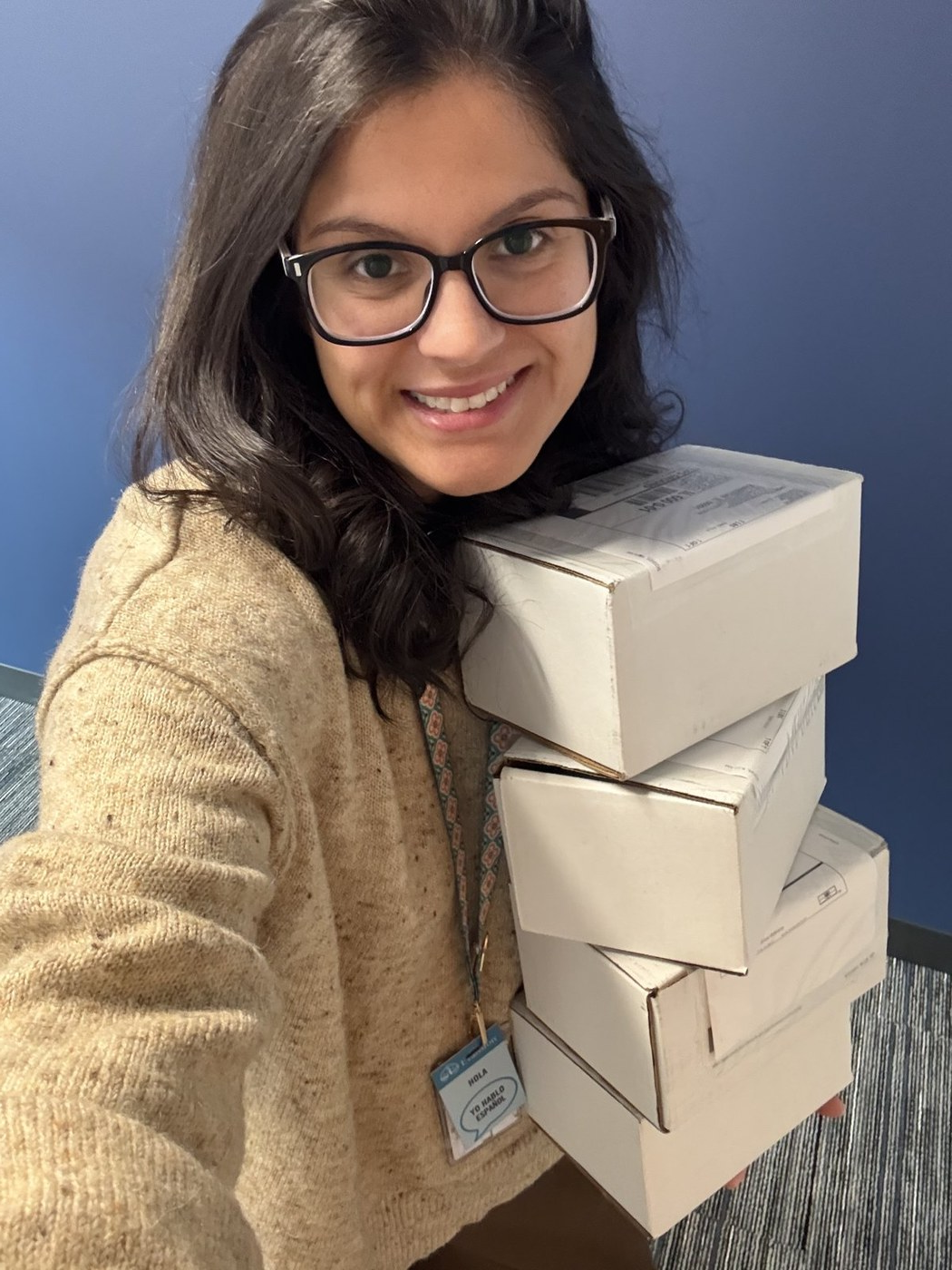 Stephanie Mendoza carrying a stack of records boxes at City Hall